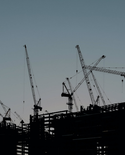 Baustelle mit Kräne in Dämmerung